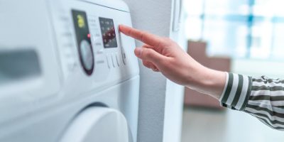 Hausfrau bedient Wäschetrockner